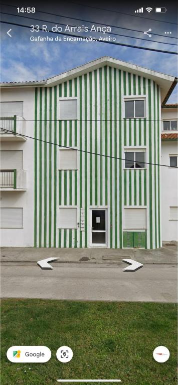 a building with a green and white stripe at Casa Das Riscas Verdes in Gafanha da Encarnação