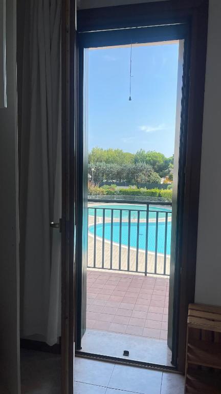 an open door with a view of a swimming pool at Casa Origine, appartamento vista piscina, al mare in Cavallino-Treporti