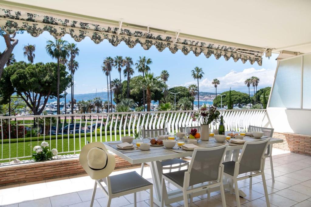 une salle à manger avec une table et des chaises et une grande fenêtre dans l'établissement 3-Br Apartment with Sea View & Terrace La Croisette, à Cannes