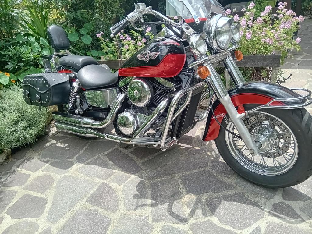 Belli come il Sole في Serri: دراجة نارية حمراء متوقفة في حديقة مليئة بالزهور