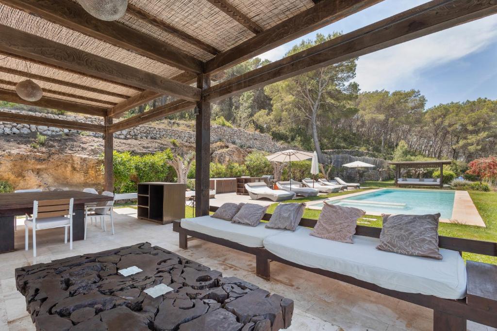 an outdoor patio with a couch and a pool at Can Ribes Ibiza in Illes Balears