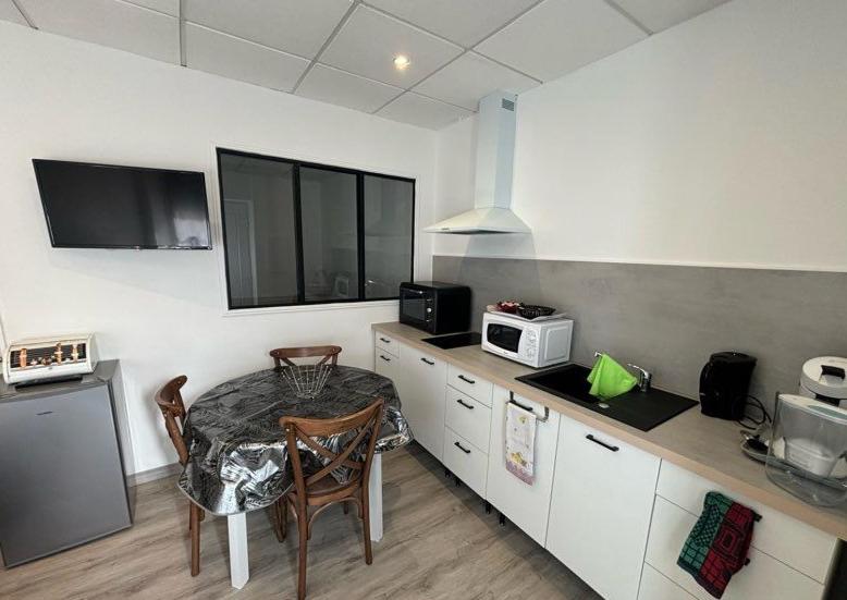 een keuken met een tafel en een magnetron bij La Fontaine in Neussargues en Pinatelle