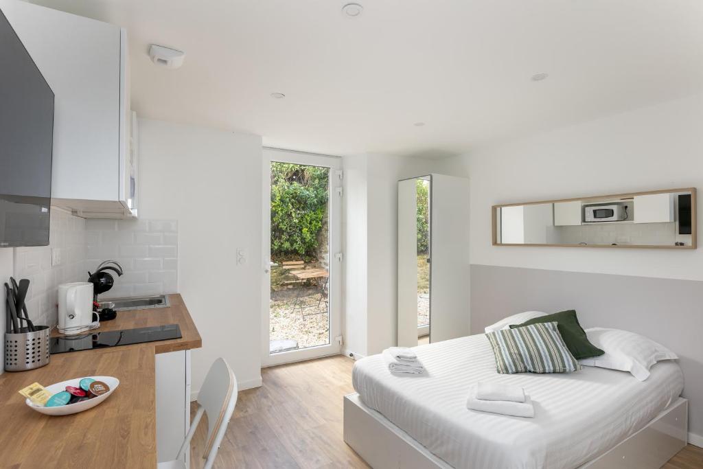 Il comprend un salon blanc avec un lit et une cuisine. dans l'établissement L'Ankou, à Brest