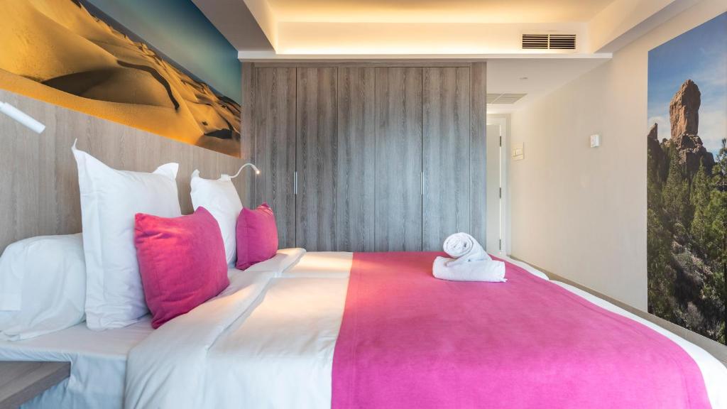 a bedroom with a large bed with pink pillows at Labranda Marieta & Spa - Adults Only in Playa del Ingles