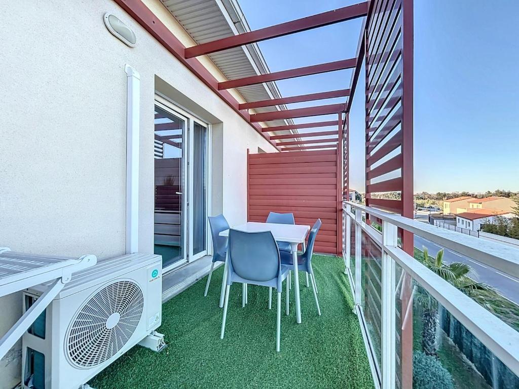 un patio avec une table et des chaises sur un balcon dans l'établissement 3326-Appartement 4 couchages avec une piscine, à Argelès-sur-Mer