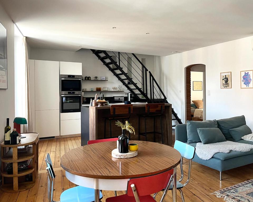 un salon avec une table et un canapé dans l'établissement L'Heure Bleue, Grand T2 stylé & lumineux, à Montauban