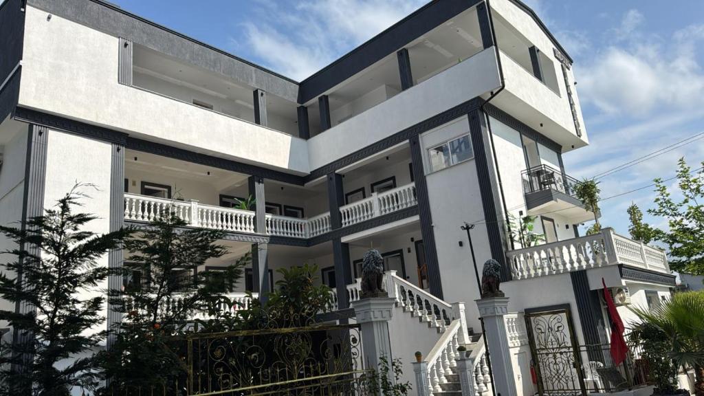 uma grande casa branca com varandas e uma cerca em Hotel Vila AARON em Durrës