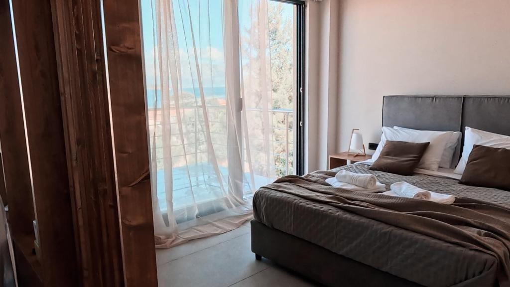 a bedroom with a bed and a large window at Dris Suites in Nikiana