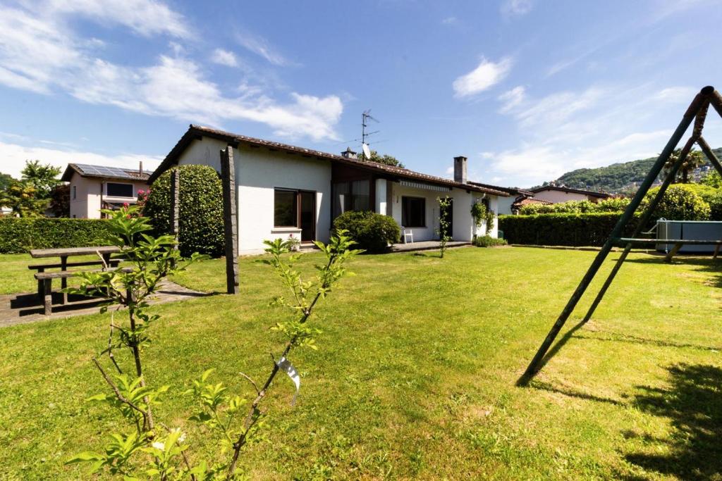 a yard with a house and a swing at Oasi del Ticino in Magliaso