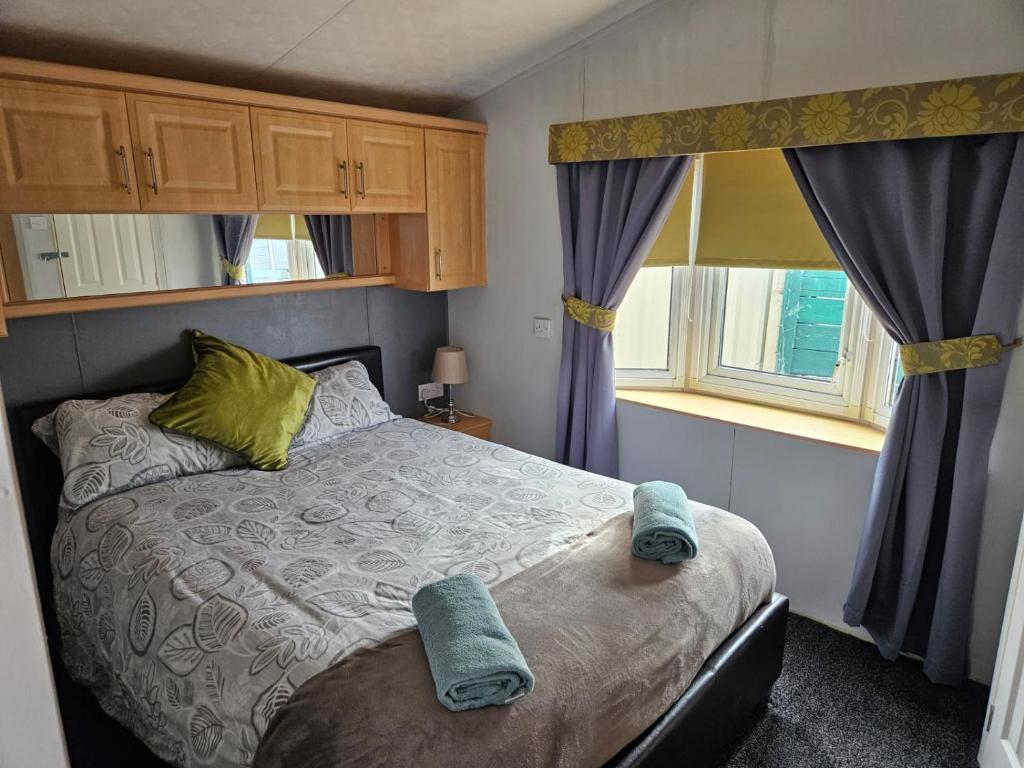 una camera da letto con un letto con asciugamani blu sopra di Beautiful Mobile Home a Tralee