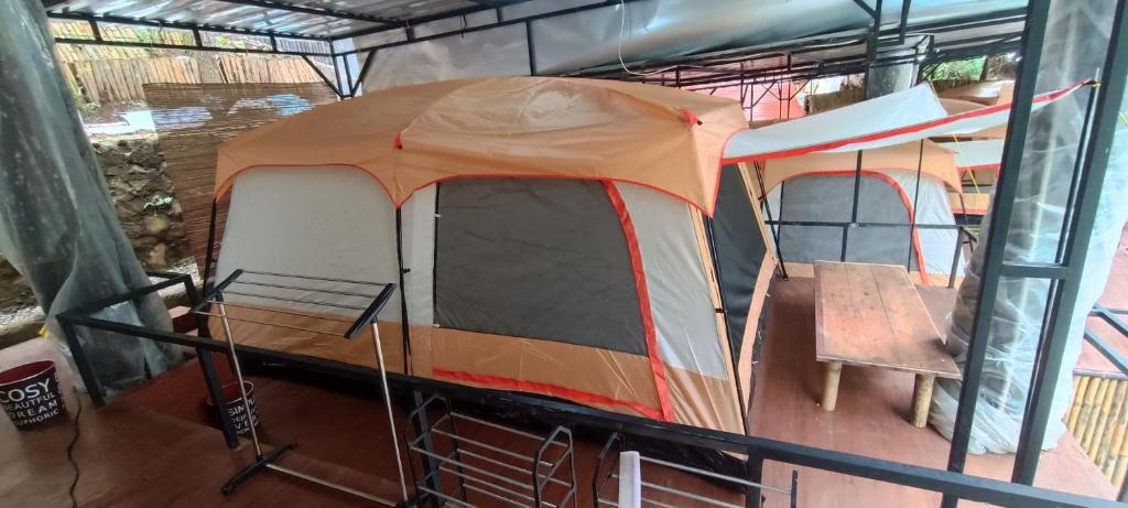 a tent with a chair and a table in it at Cabin rahong riverside in Palayangan