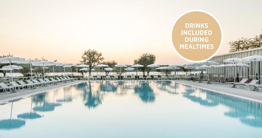 a picture of a swimming pool with a sign that reads drinks included driving weddings at Falkensteiner Hotel Park Punat in Punat