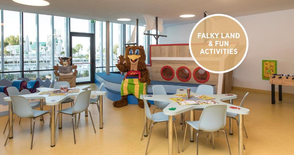 a room with tables and a mascot in a restaurant at Falkensteiner Hotel Park Punat in Punat