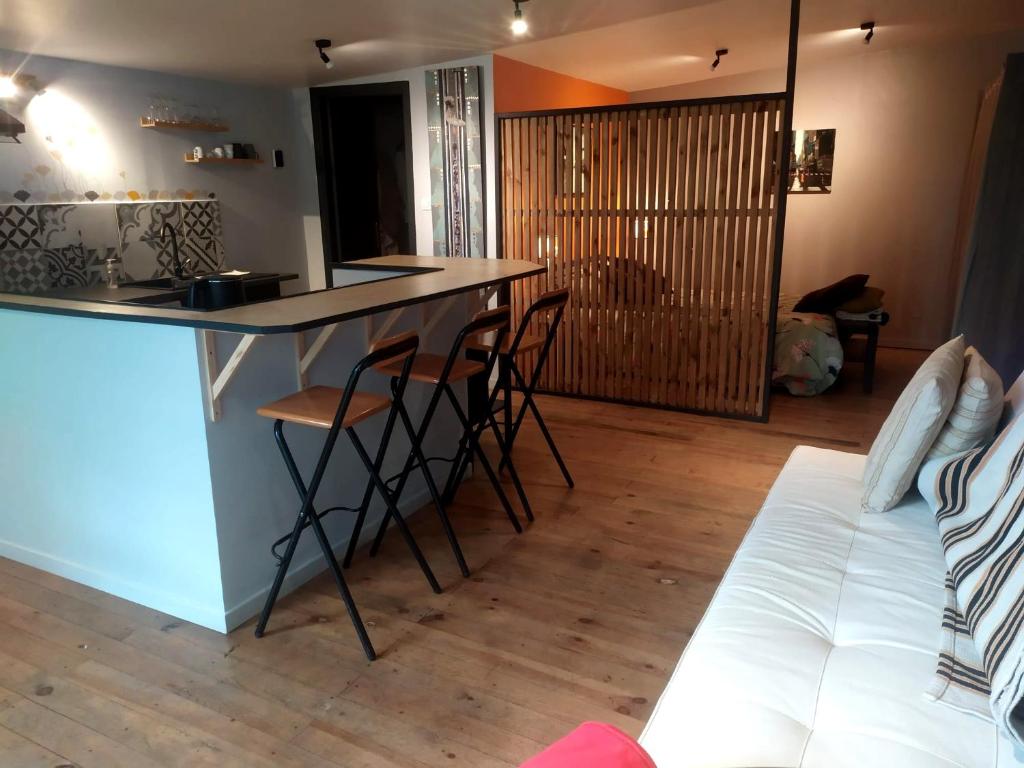 a kitchen with a bar and a couch in a room at La Villa Saint Ghislain in Thivencelle