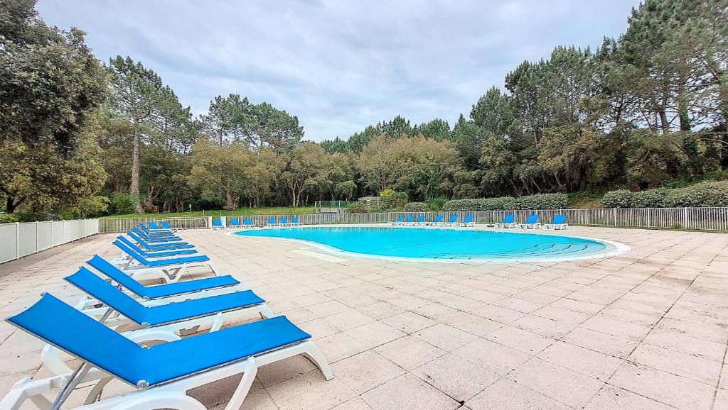 - un groupe de chaises longues bleues et une piscine dans l'établissement S-Pinsolle 02-Soustons plage Appartement deux pièces dans résidence avec piscine proche du golf, à Soustons