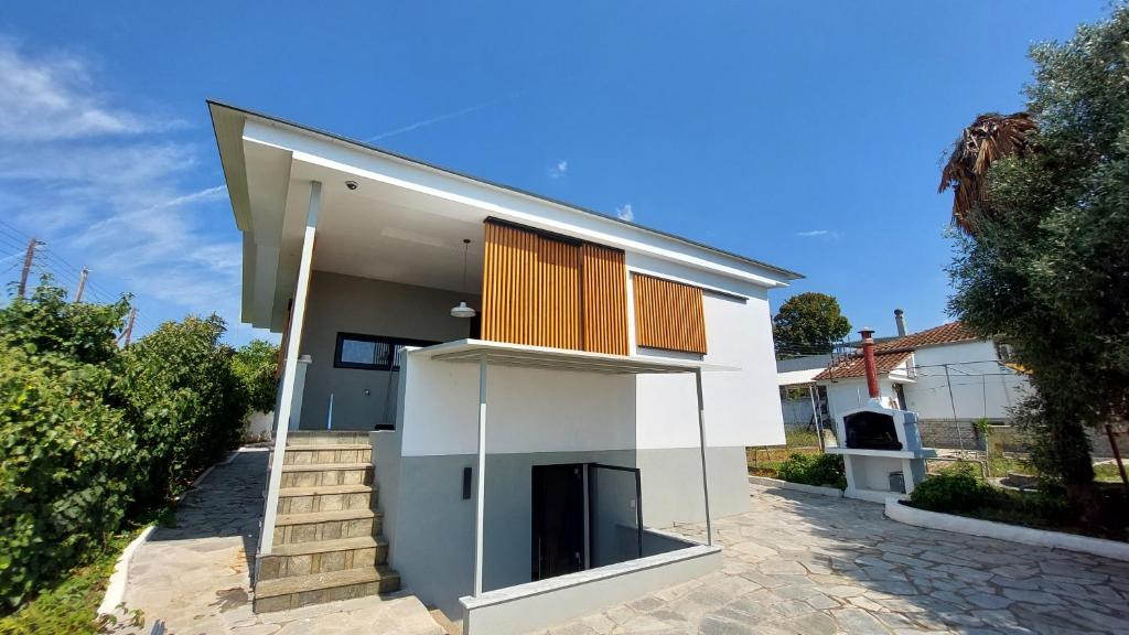 a white house with a staircase in front of it at Modern Summer House Kalimera in Epanomi