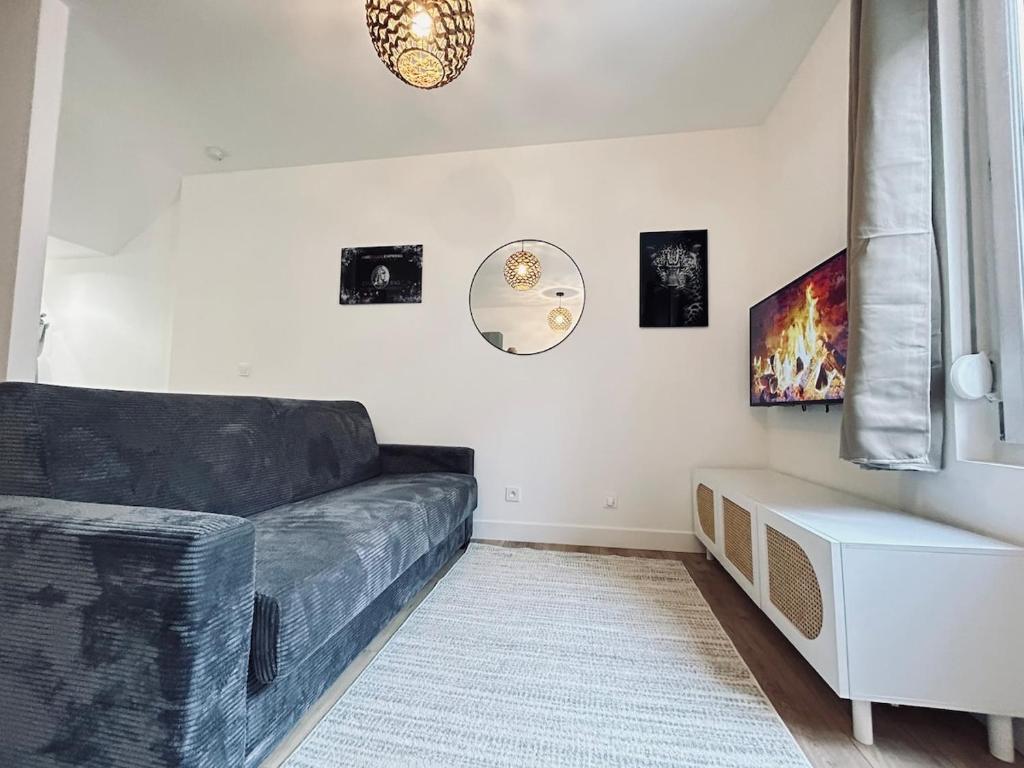 - un salon avec un canapé noir et une fenêtre dans l'établissement 2 Clairmarais T2 en duplex proche gare centre, à Reims