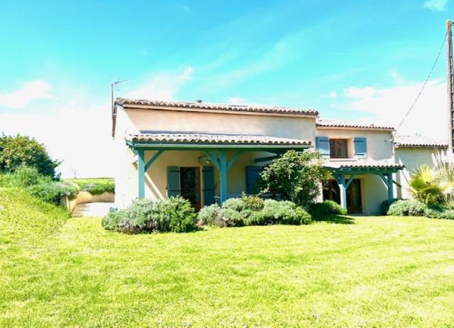 une petite maison avec une pelouse verte en face de celle-ci dans l'établissement Les Lavandes, à Eymet