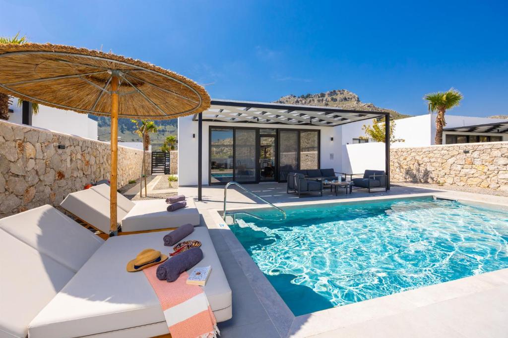 a villa with a swimming pool and an umbrella at Villa 13 Zendo in Kolymbia
