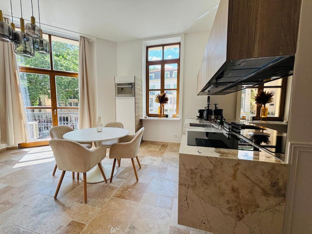 une cuisine avec une table, des chaises et un comptoir dans l'établissement Le Sainte Rose Standing, Cannes center on foot, à Cannes