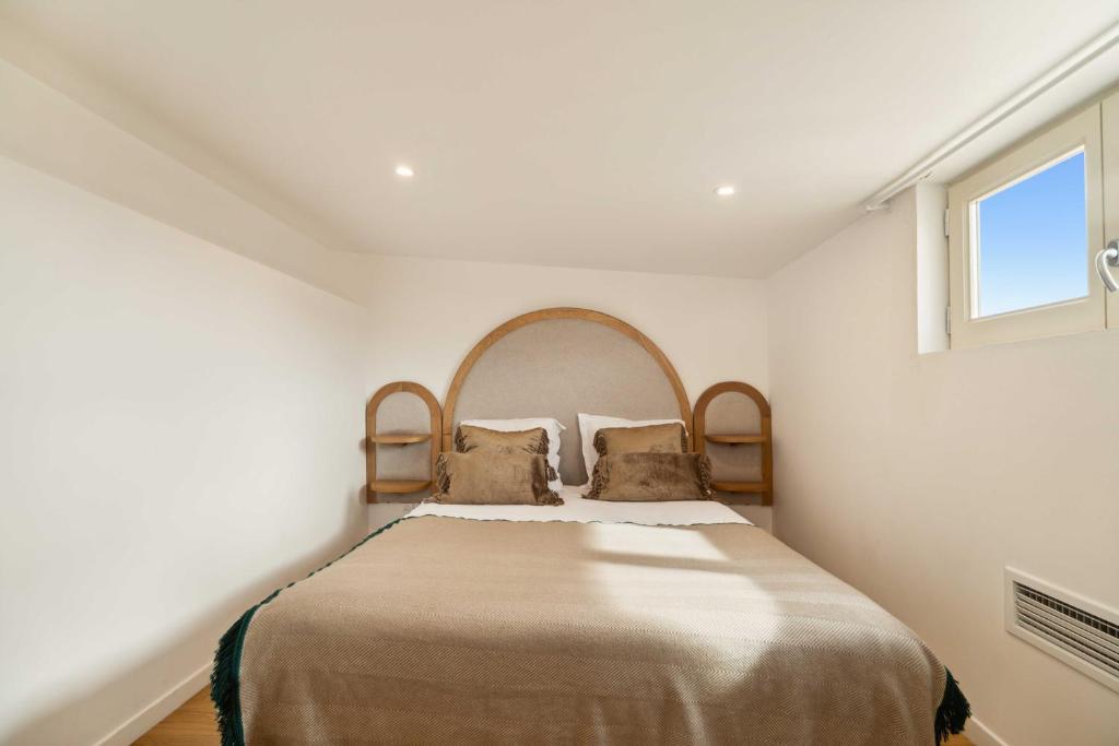 un lit dans une chambre blanche avec une fenêtre dans l'établissement Magnificent apartment -1BR-2P- Centre Saint-Tropez, à Saint-Tropez