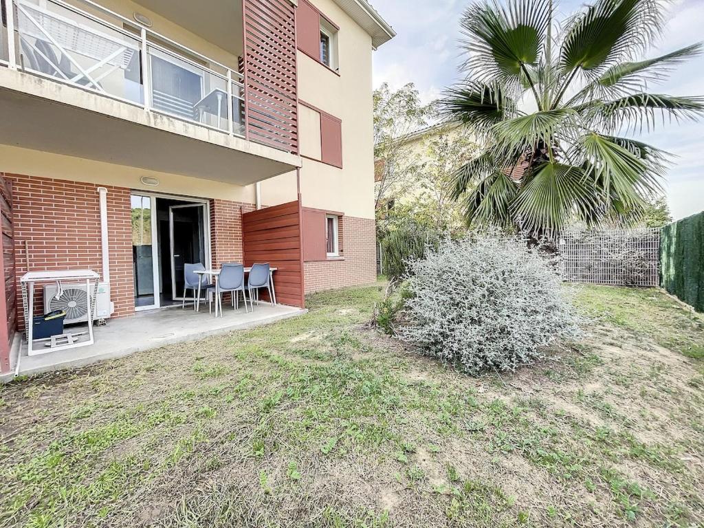 een huis met een palmboom en een patio bij 3313-Appartement 8 couchages avec piscine in Argelès-sur-Mer