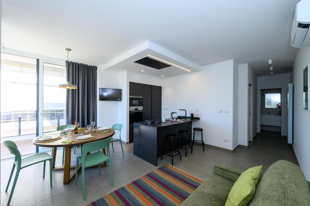 ein Wohnzimmer und eine Küche mit einem Tisch und Stühlen in der Unterkunft Appartamento - Brand New Luxury Apartment - Giardini Naxos, Recanati in Giardini-Naxos