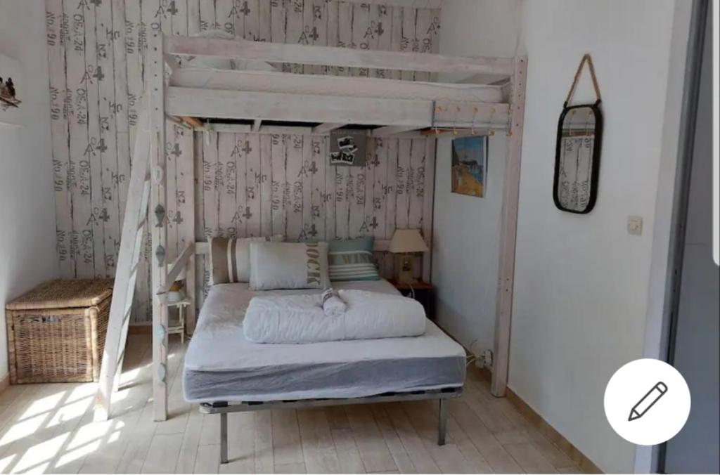 une chambre avec un lit superposé avec une échelle dans l'établissement Les Lauriers Roses, à Noirmoutier-en-l'lle