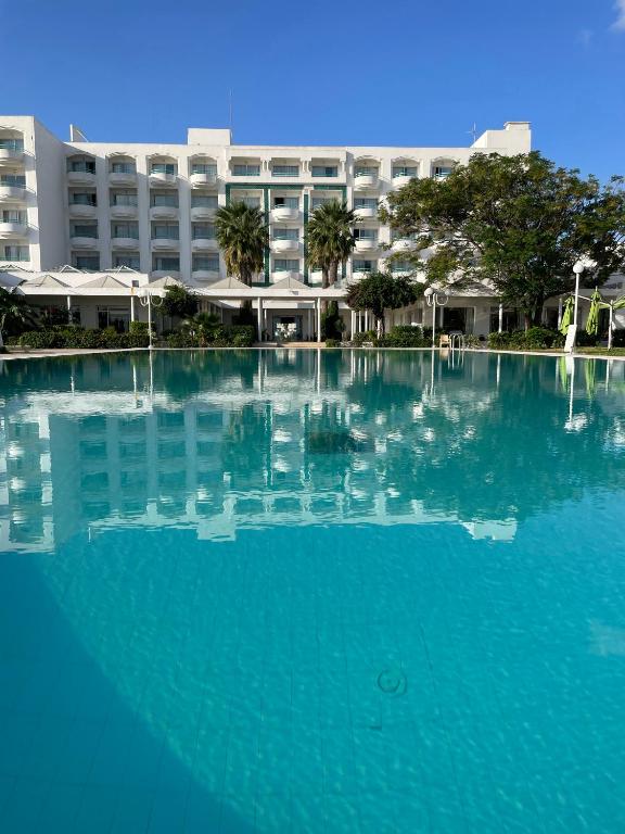 a large pool of blue water in front of a building at Bizerta Resort Congres & SPA in Bizerte