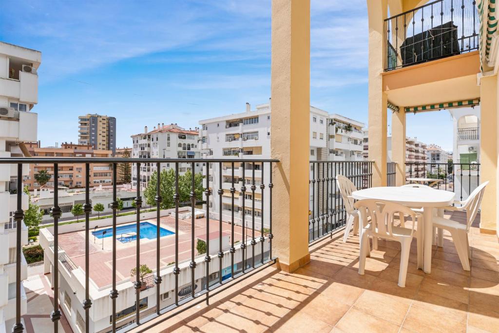 balcón con mesa, sillas y vistas a la piscina en Apt ideal location by Costarentals - Ref 138, en Santa Fe de los Boliches