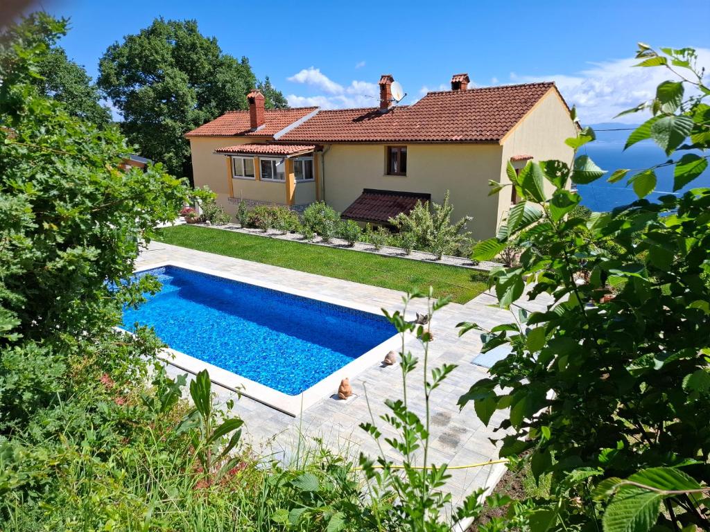a swimming pool in front of a house at Casa Andrea in Mošćenička Draga