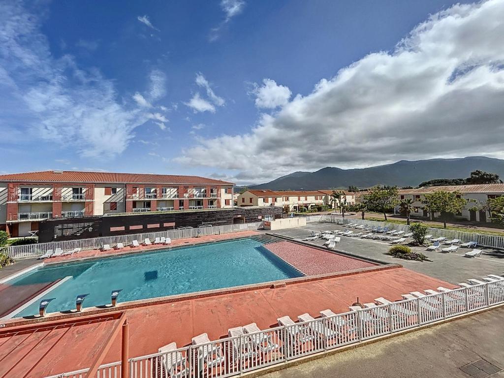 ein großes Schwimmbad mit Stühlen und einem Gebäude in der Unterkunft 3304-T3 dans une résidence avec piscine in Argelès-sur-Mer
