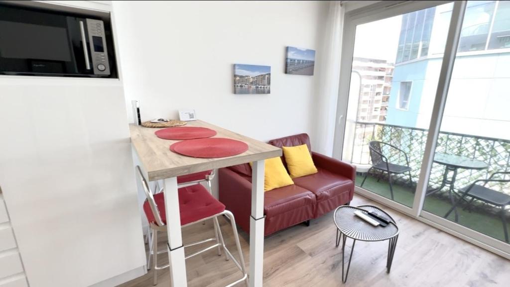 Ce petit appartement comprend une table et un canapé. dans l'établissement ApartHotel Riviera - Balcon Lenval Sea View with AC Promenade des Anglais, à Nice