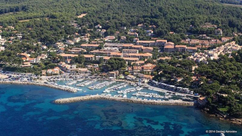 une vue aérienne d'une station balnéaire avec des bateaux dans l'eau dans l'établissement La Pinède entre village et plage Saint Cyr sur Mer, à Saint-Cyr-sur-Mer