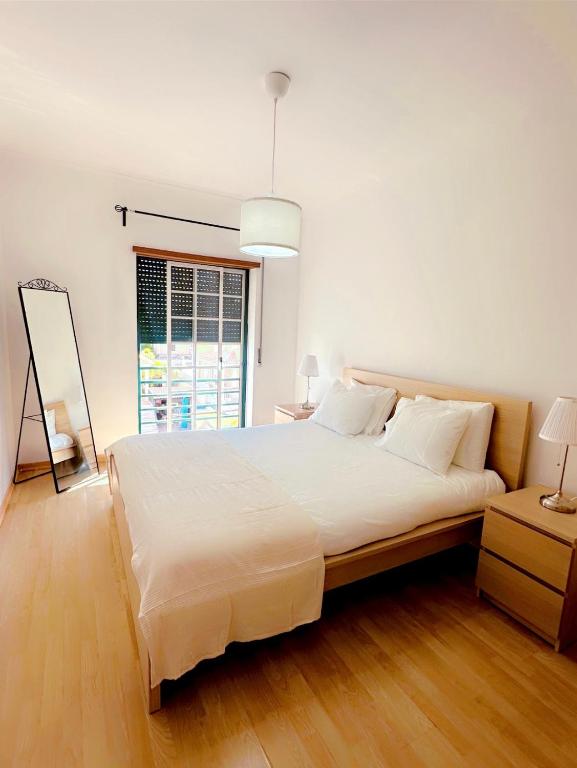 a large white bed in a room with a window at Elegant Getaway II - Lisbon- 2 bedroom apartment in Montijo in Atalaia