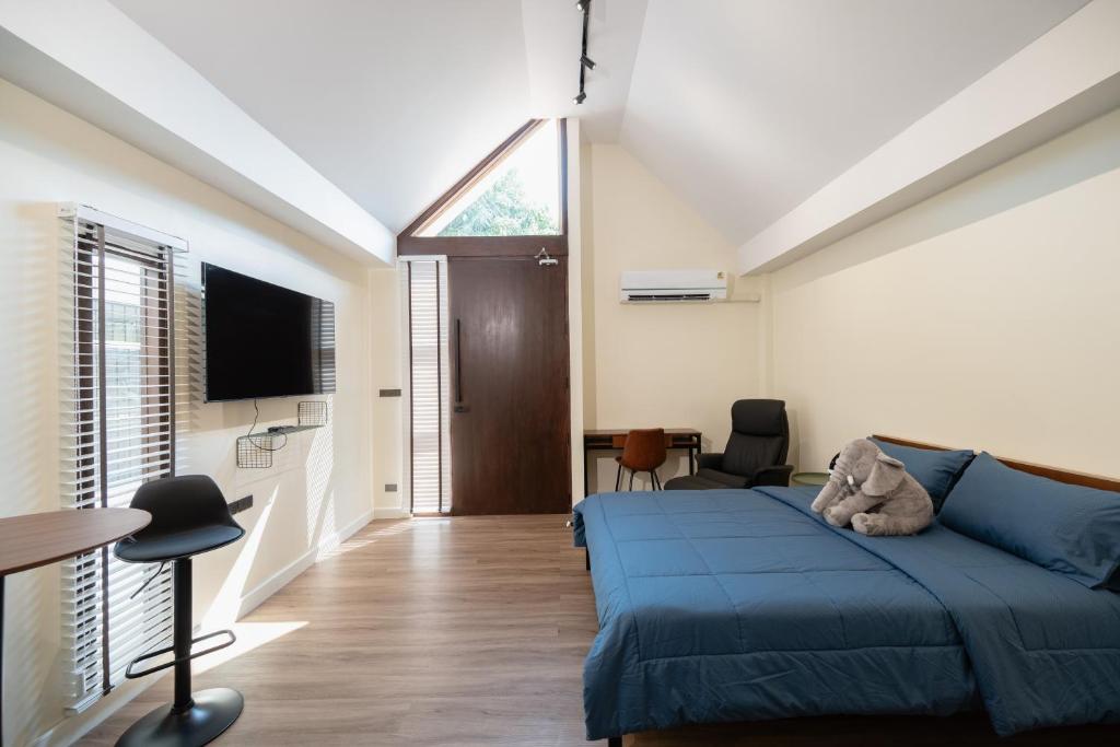 a bedroom with a blue bed and a tv at Morya House in Bangkok