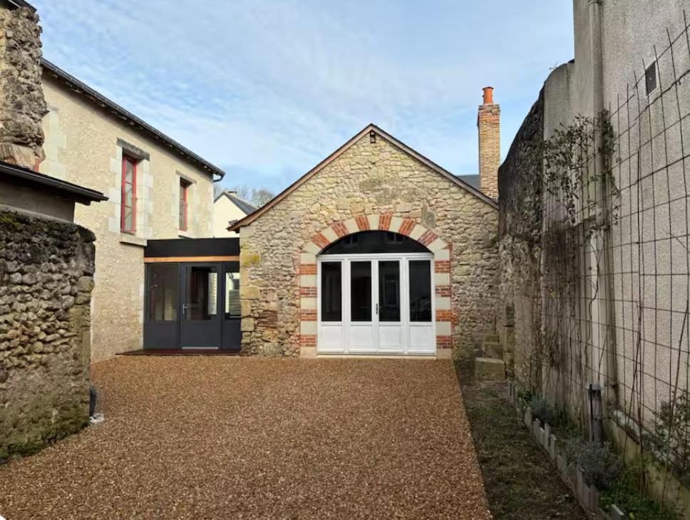une maison en briques avec une porte de garage blanche dans l'établissement Palais PépinleBref Chateaux de la Loire Tours - 3 étoiles, à Vernou-sur-Brenne