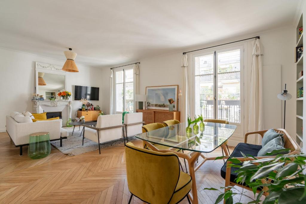 un salon avec une table en verre et des chaises dans l'établissement Veeve - The Spirit Lifter, à Paris