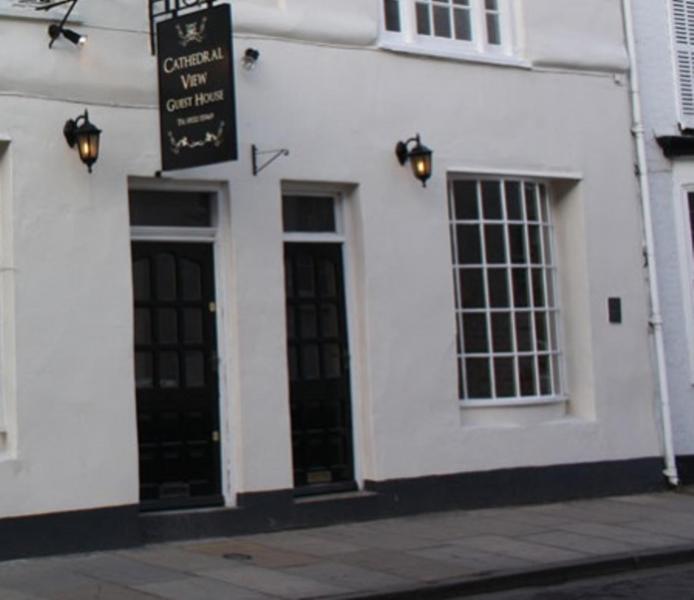 a white building with a sign on the side of it at Cathedral View Guest House in Lincoln