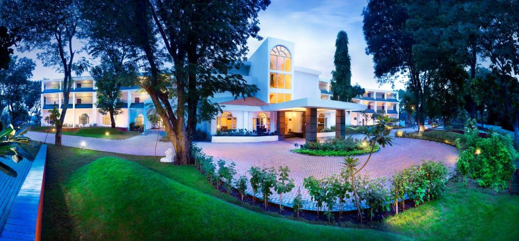 an exterior view of a building with a garden at Gir Serai - IHCL SeleQtions in Sasan Gir