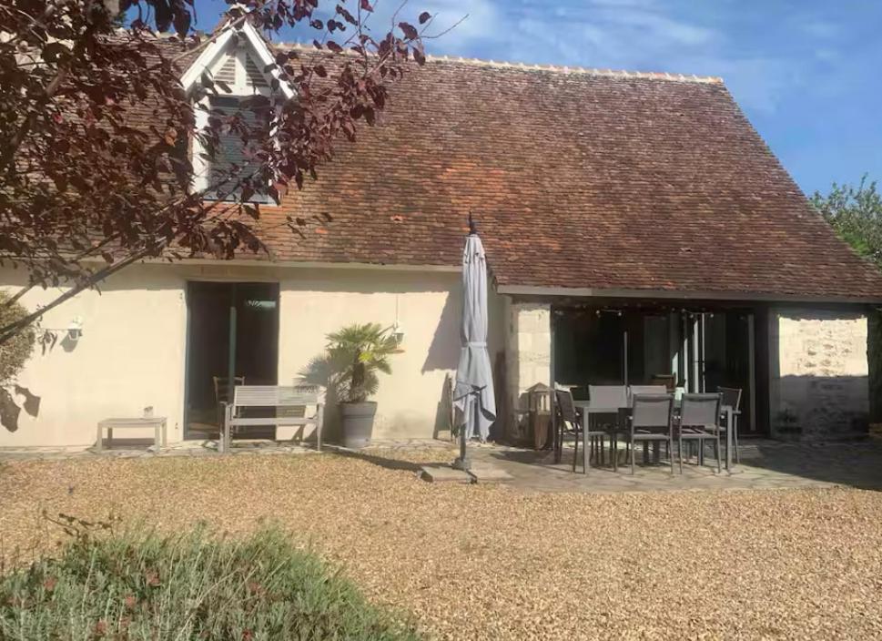 a patio with a umbrella and a table and chairs at La Pidellerie bord de Cher-Châteaux de la Loire in Véretz