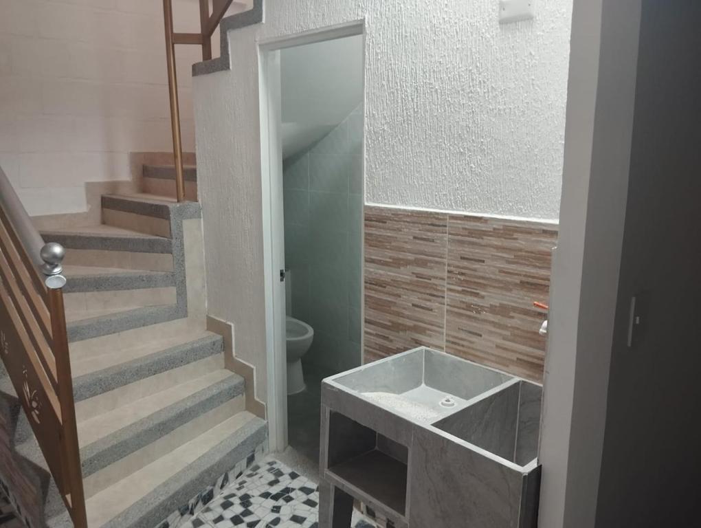 a bathroom with a staircase and a sink and a toilet at Casa para vacaciones Neiva Rivera Huila in Rivera