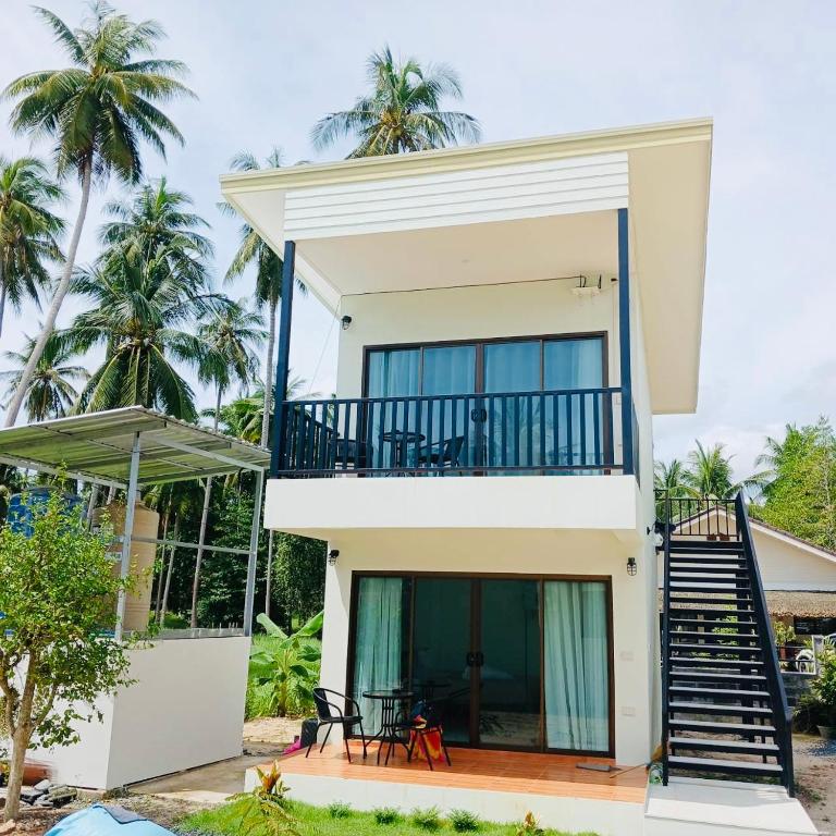 帕干岛First Light sunset view bungalow的带阳台和棕榈树的白色房屋