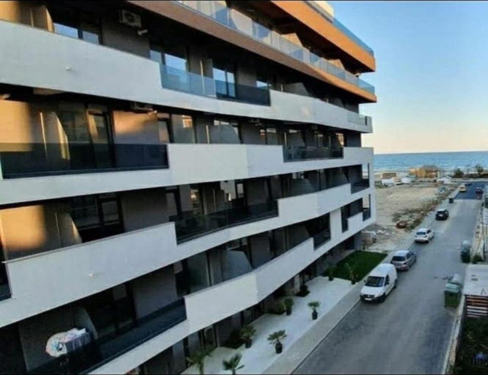 ein Apartmenthaus mit draußen geparkt Autos in der Unterkunft Blue Apartment in Năvodari