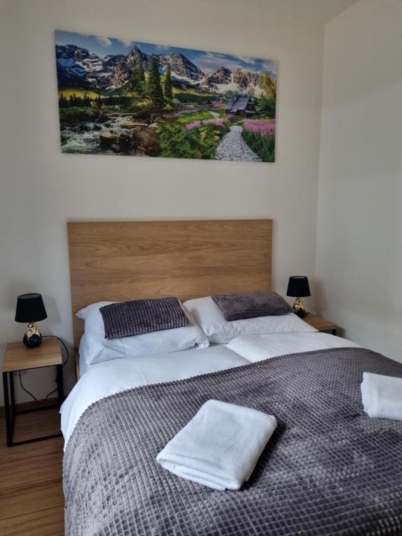 ein Schlafzimmer mit zwei Betten und einem Gemälde an der Wand in der Unterkunft Szczyrkowska Ostoja in Szczyrk