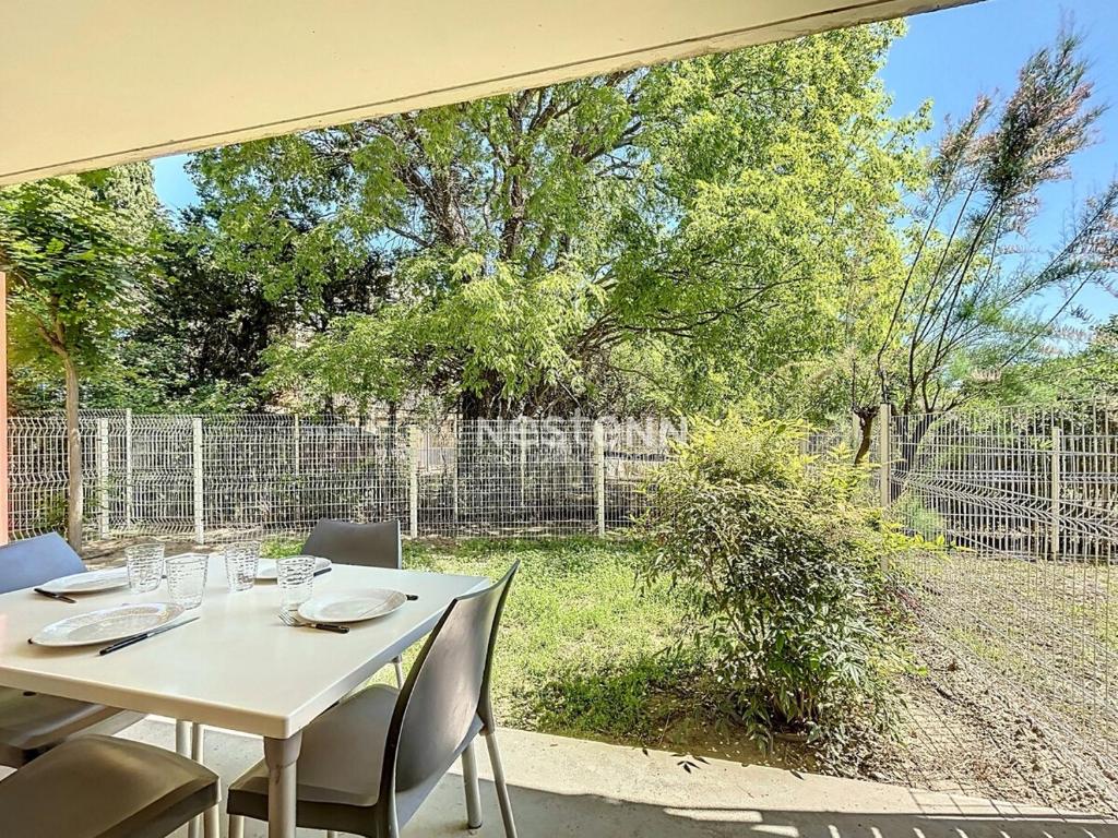 une table blanche et des chaises sur une terrasse dans l'établissement 2950-Appartement une chambre avec piscine, à Argelès-sur-Mer