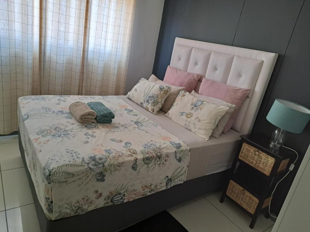 a small bedroom with a bed with a floral bedspread at Casa do Dylan in Khomas Region