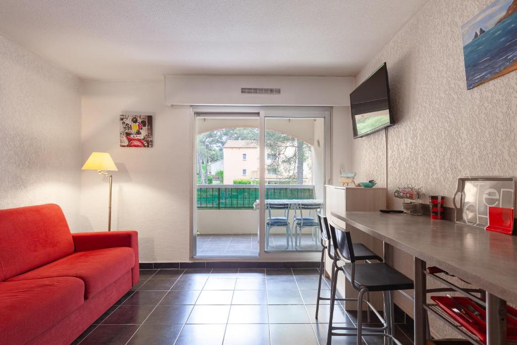 un salon avec un canapé rouge et une cuisine dans l'établissement Chez Alain et Martine, à Saint-Mandrier-sur-Mer