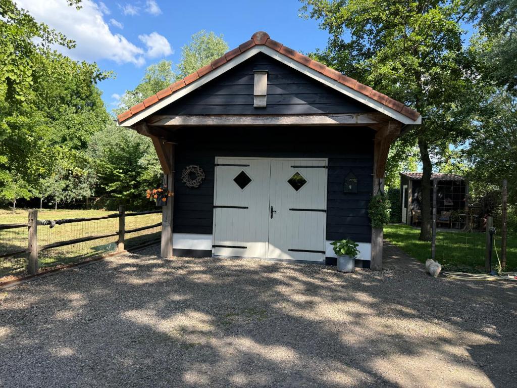 a blue garage with a white door and a fence at Het plekje dat niemand wist in Ederveen