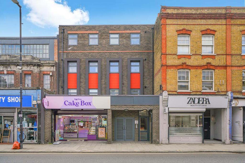 Hotel 360 Cosy Home Greenwich, a brick building on a city street with stores at 360 Cosy Home Greenwich in London
